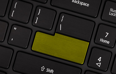 Image showing Laptop computer keyboard with blank yerllow button