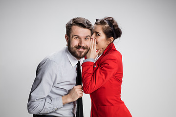 Image showing Young man telling gossips to his woman colleague at the office