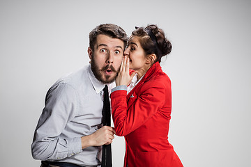 Image showing Young man telling gossips to his woman colleague at the office