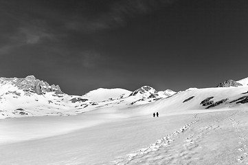 Image showing Two hikers on snow plateau (black and white)