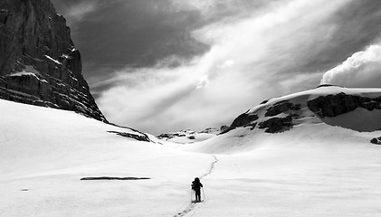 Image showing Hiker on snow plateau. Black and white panoramic view.