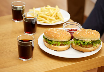 Image showing close up of fast food and drinks on table at home