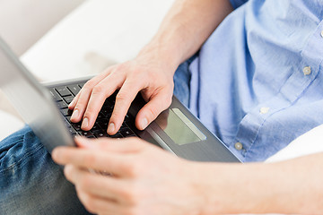 Image showing close up of man typing on laptop computer at home