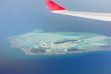 Image showing close up of airplane wing above island in ocean