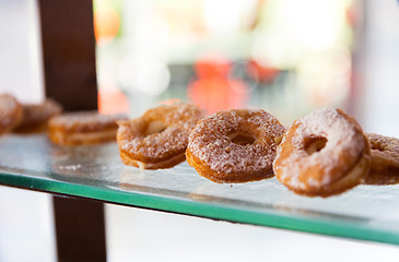 Image showing close up of sugared donuts on showcase shelf