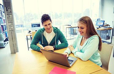 Image showing happy students with laptop and books at library