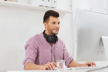 Image showing creative man with headphones and computer