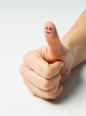 Image showing close up of hand showing thumb with smiley face