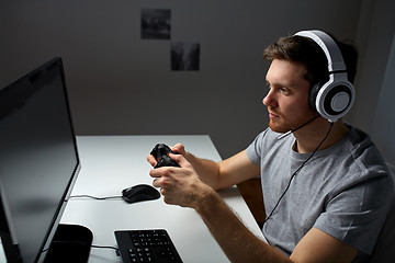 Image showing man in headset playing computer video game at home