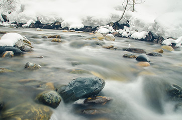 Image showing Rapidly flowing winter mountain river, blurred by a slow shutter speed