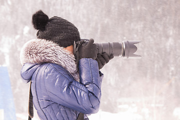 Image showing Young girl photographed in the winter in a snow storm on a SLR camera with telephoto lens