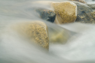 Image showing Current between the stones of the river, blurred by a slow shutter speed
