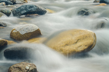 Image showing Stone is in the mountain river, blurred by a slow shutter speed