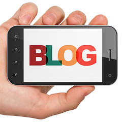 Image showing Web design concept: Hand Holding Smartphone with Blog on  display