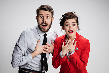 Image showing The surprised business man and woman smiling on a gray background