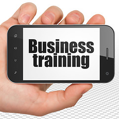 Image showing Education concept: Hand Holding Smartphone with Business Training on display