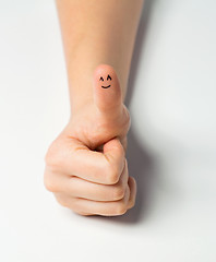 Image showing close up of hand showing thumb with smiley face