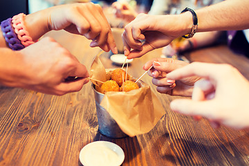 Image showing close up of people hands taking cheese balls