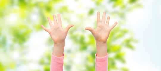 Image showing close up of little child hands raised upwards