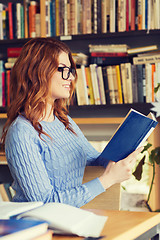 Image showing happy student girl reading book in library