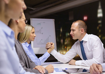 Image showing businesswoman and businessman arm wrestling