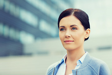 Image showing young smiling businesswoman over office building