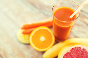 Image showing close up of fresh juice glass and fruits on table