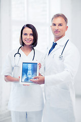 Image showing two doctors showing x-ray on tablet pc