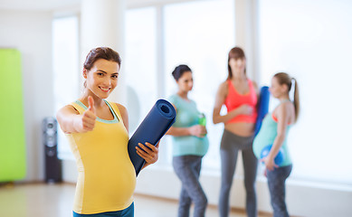 Image showing pregnant woman with mat in gym showing thumbs up 