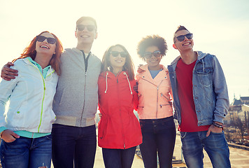 Image showing happy teenage friends in shades hugging on street