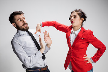 Image showing The sad business man and woman conflicting on a gray background