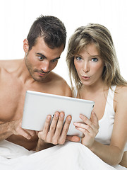 Image showing attractive couple watching things in a tablet