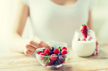 Image showing close up of woman hands with yogurt and berries