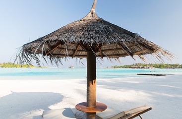 Image showing palapa and sunbeds by sea on maldives beach
