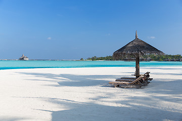 Image showing palapa and sunbeds by sea on maldives beach