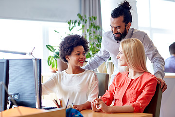 Image showing happy creative team with computer in office