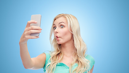 Image showing funny young woman taking selfie with smartphone