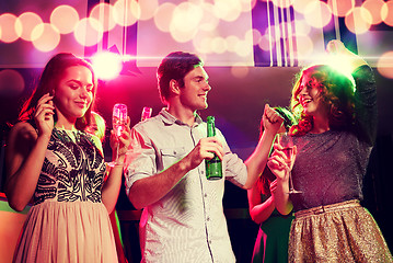 Image showing smiling friends with wine glasses and beer in club