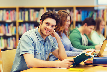 Image showing happy student boy reading book in library