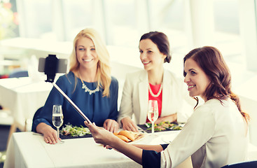 Image showing women with smartphone taking selfie at restaurant