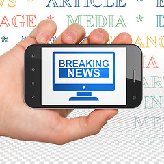 Image showing News concept: Hand Holding Smartphone with Breaking News On Screen on display