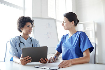 Image showing happy doctors with tablet pc meeting at hospital