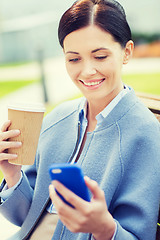 Image showing smiling woman with coffee and smartphone
