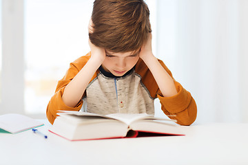 Image showing student boy reading book or textbook at home
