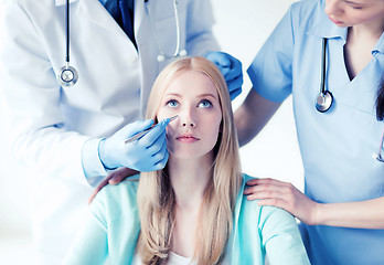 Image showing plastic surgeon and nurse with patient