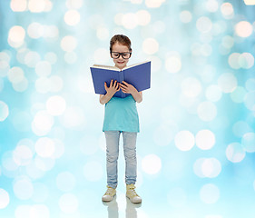 Image showing happy little girl in eyeglasses reading book