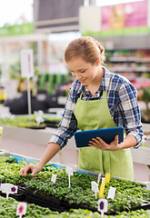 Image showing happy woman with tablet pc in greenhouse