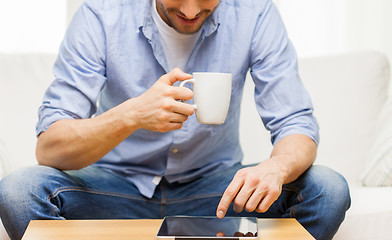 Image showing close up of man with tablet pc and tea cup at home