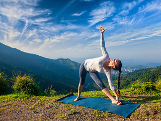 Image showing Woman doing Ashtanga Vinyasa yoga asana Utthita trikonasana