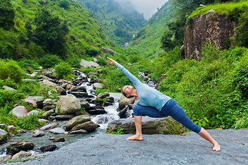 Image showing Woman practices yoga asana Utthita Parsvakonasana outdoors